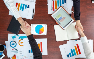 Business reports and charts spread across a desk