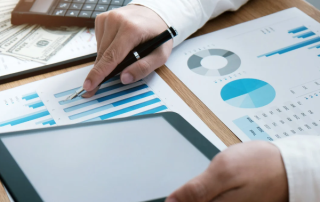 Pen and calculator over financial statements and charts