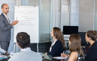 Manager leading a meeting while the team takes notes
