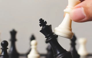 Hand moving a chess piece, a strategic capital decision