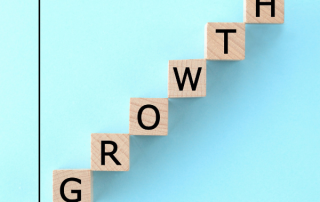 Wooden blocks spelling growth, stepping up a chart axis